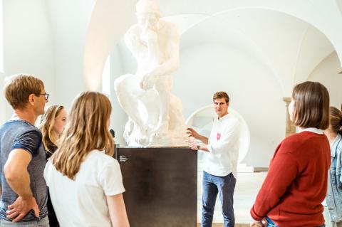 Bei einer Führung wird den Besuchern näheres zu einer Statue erklärt.