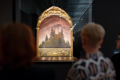 eine Dame von hinten vor dem Gemälde Tetschener Altar von Caspar Davir Friedrich